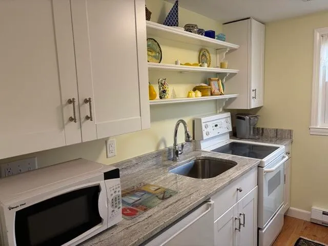 a kitchen with stainless steel appliances granite countertop a sink a refrigerator and a stove