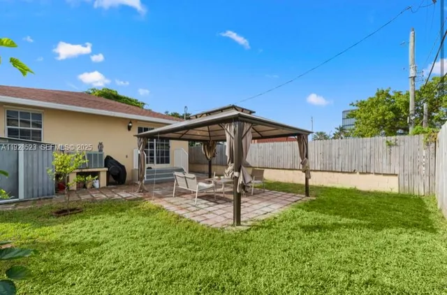 a backyard of a house with table and chairs