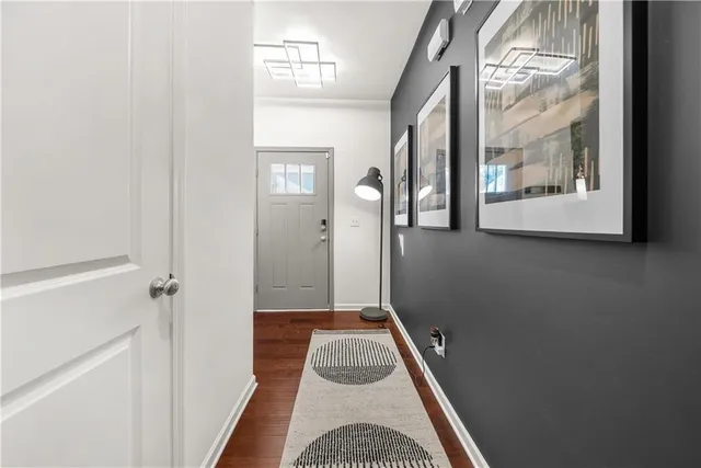 a view of a hallway with wooden floor and a cabinet
