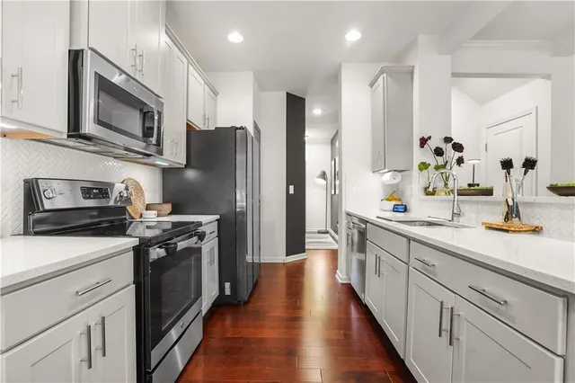 a kitchen with stainless steel appliances a stove microwave and refrigerator