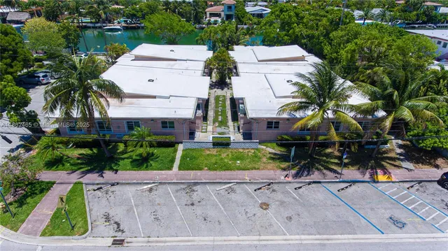 an aerial view of multiple houses with a yard