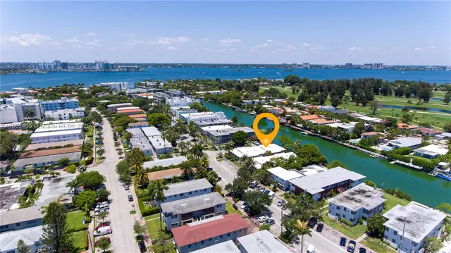 an aerial view of a city with lots of residential buildings ocean and mountain view in back
