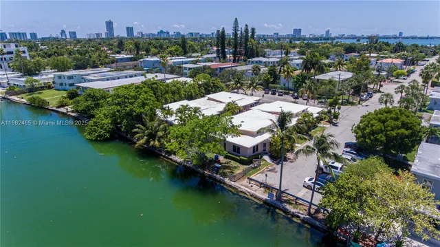 an aerial view of residential houses with outdoor space and lake view