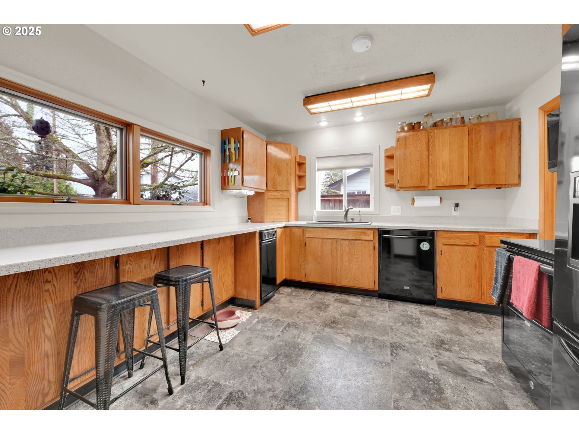 1105 West Fairview Drive Springfield, OR 97477 - Photo 11 of 46 a kitchen with stainless steel appliances kitchen island a table chairs in it and wooden floors