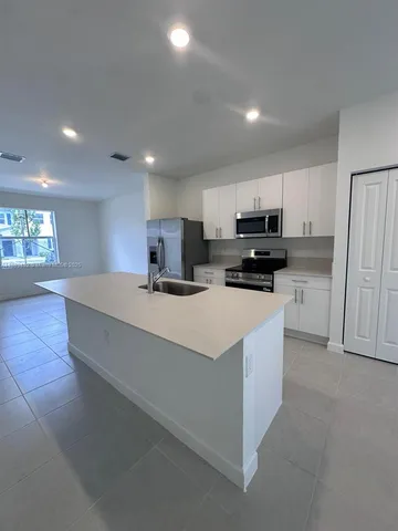 a large kitchen with stainless steel appliances lots of counter top space