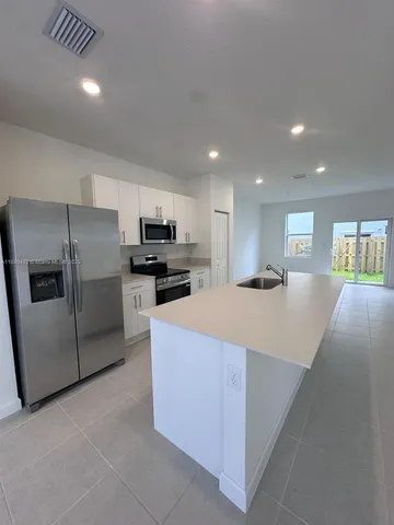 a view of a hall with kitchen