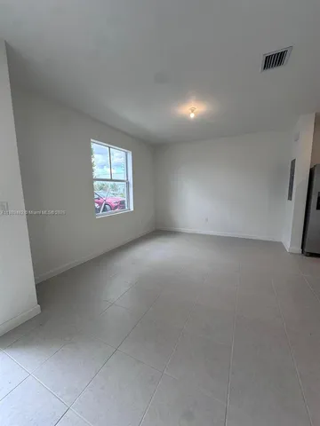 a view of empty room with kitchen