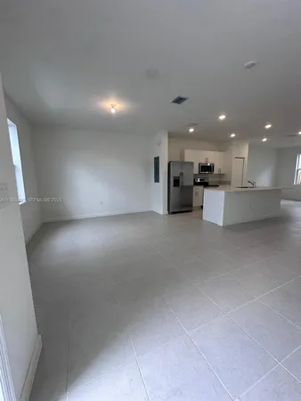 a view of empty room with kitchen