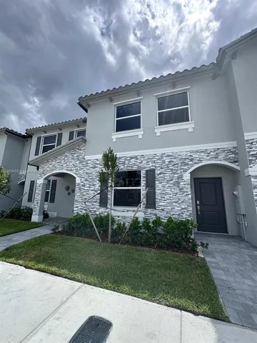 a front view of a house with a garden and yard