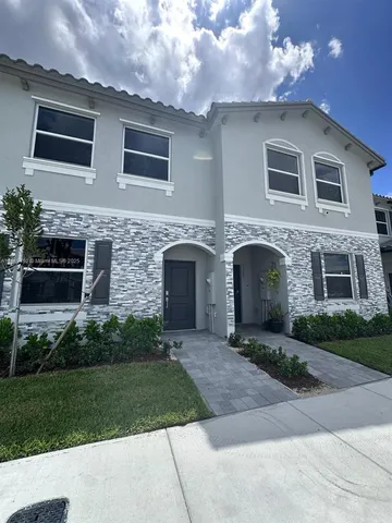 a front view of a house with a garden and garage