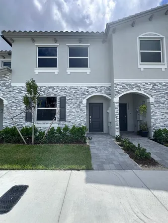 a front view of a house with a garden and garage