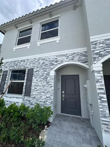 a front view of a house with yard and mountain view