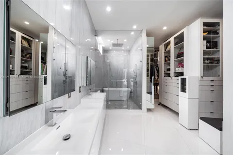 a bathroom with a double vanity sink a large mirror and shower