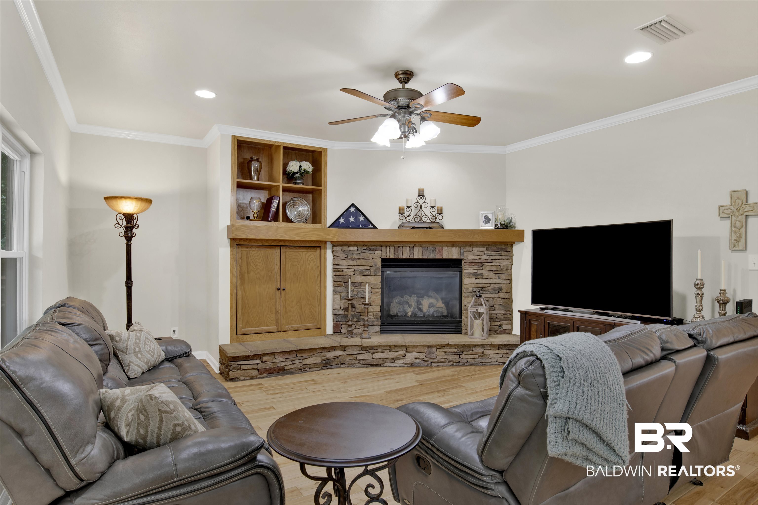 638 Southern Way Daphne, AL 36527 - Photo 5 of 26 Living room with ornamental molding, a stone fireplace, hardwood / wood-style floors, and ceiling fan
