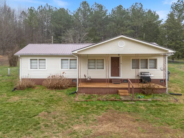 a view of a house with a yard and sitting area