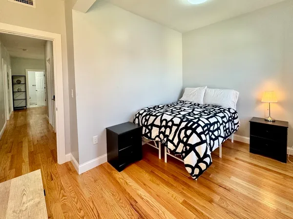a bedroom with a bed and wooden floor