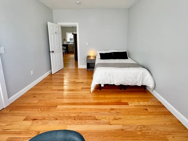 a bedroom with a bed and wooden floor