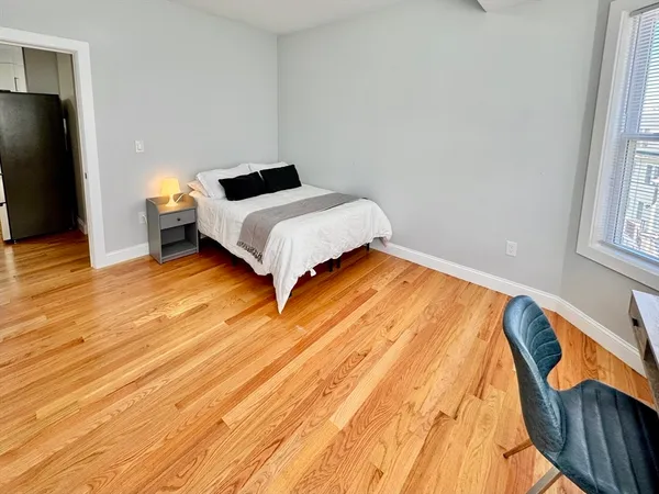 a bedroom with a bed and wooden floor