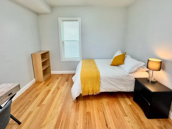a bedroom with a bed and wooden floor