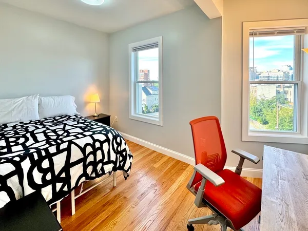 a bedroom with a bed chair and window