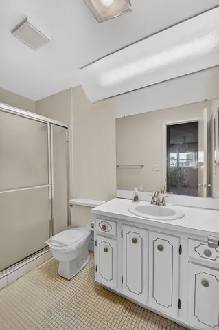 a spacious bathroom with a double vanity sink a toilet and a mirror