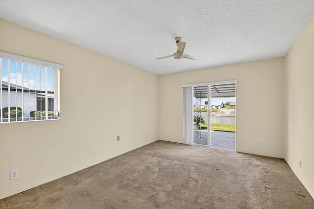 an empty room with a window and ceiling fan