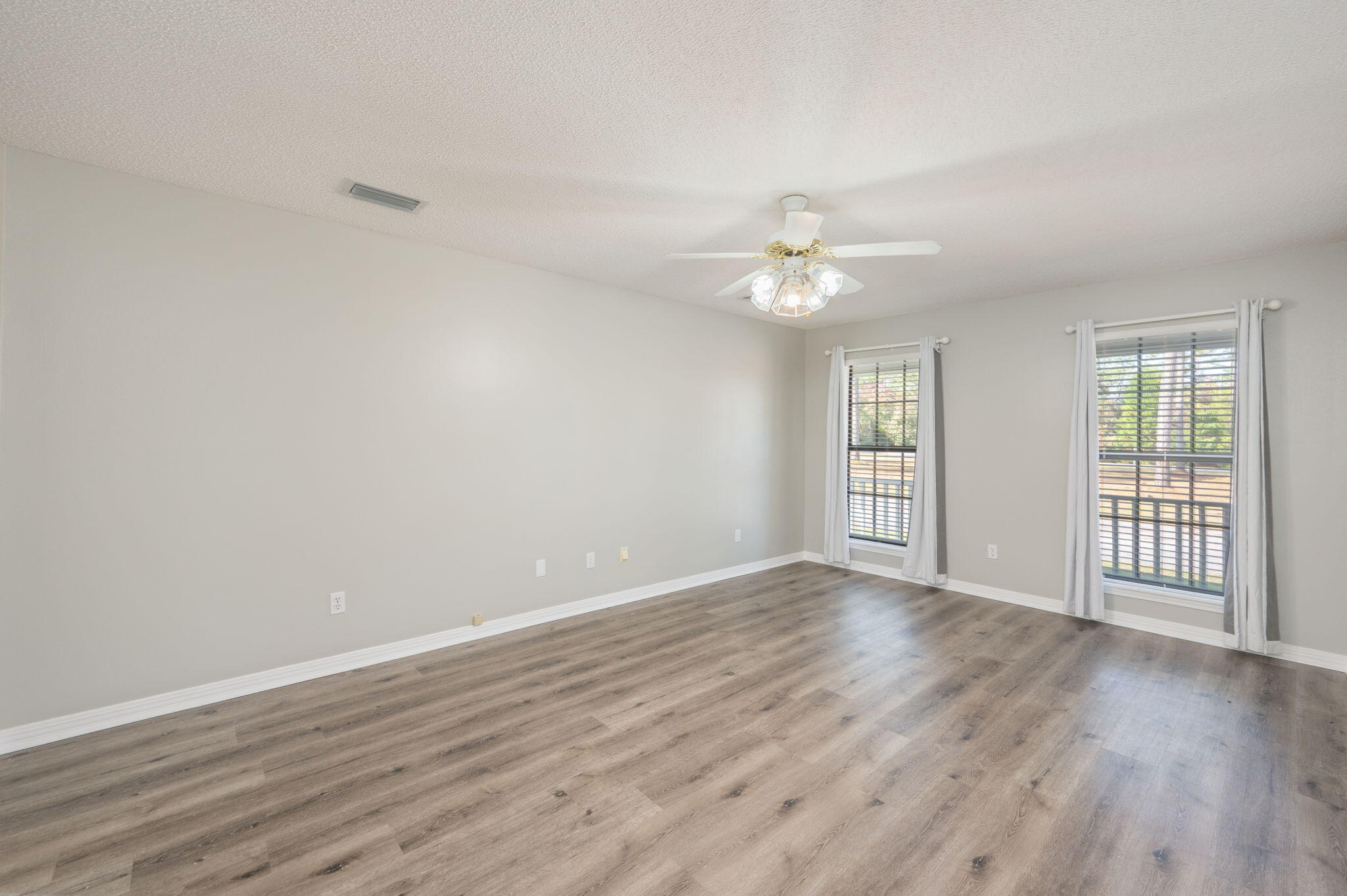 1136 10 Lake Drive DeFuniak Springs, FL 32433 - Photo 20 of 53 a view of an empty room with wooden floor and a window