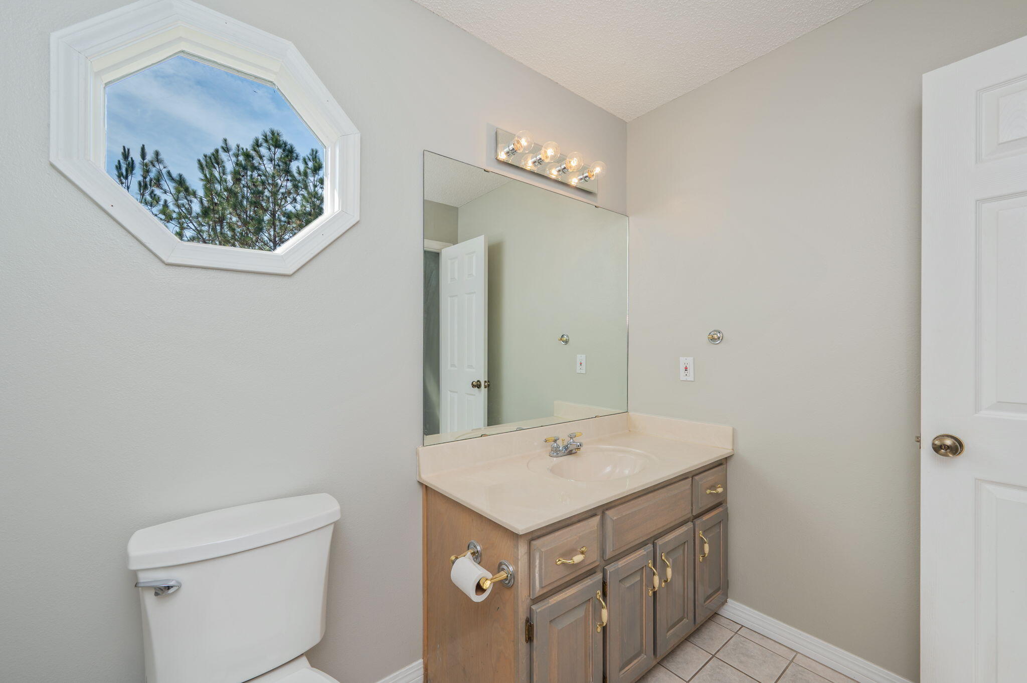 1136 10 Lake Drive DeFuniak Springs, FL 32433 - Photo 29 of 53 a bathroom with a sink a mirror and a toilet