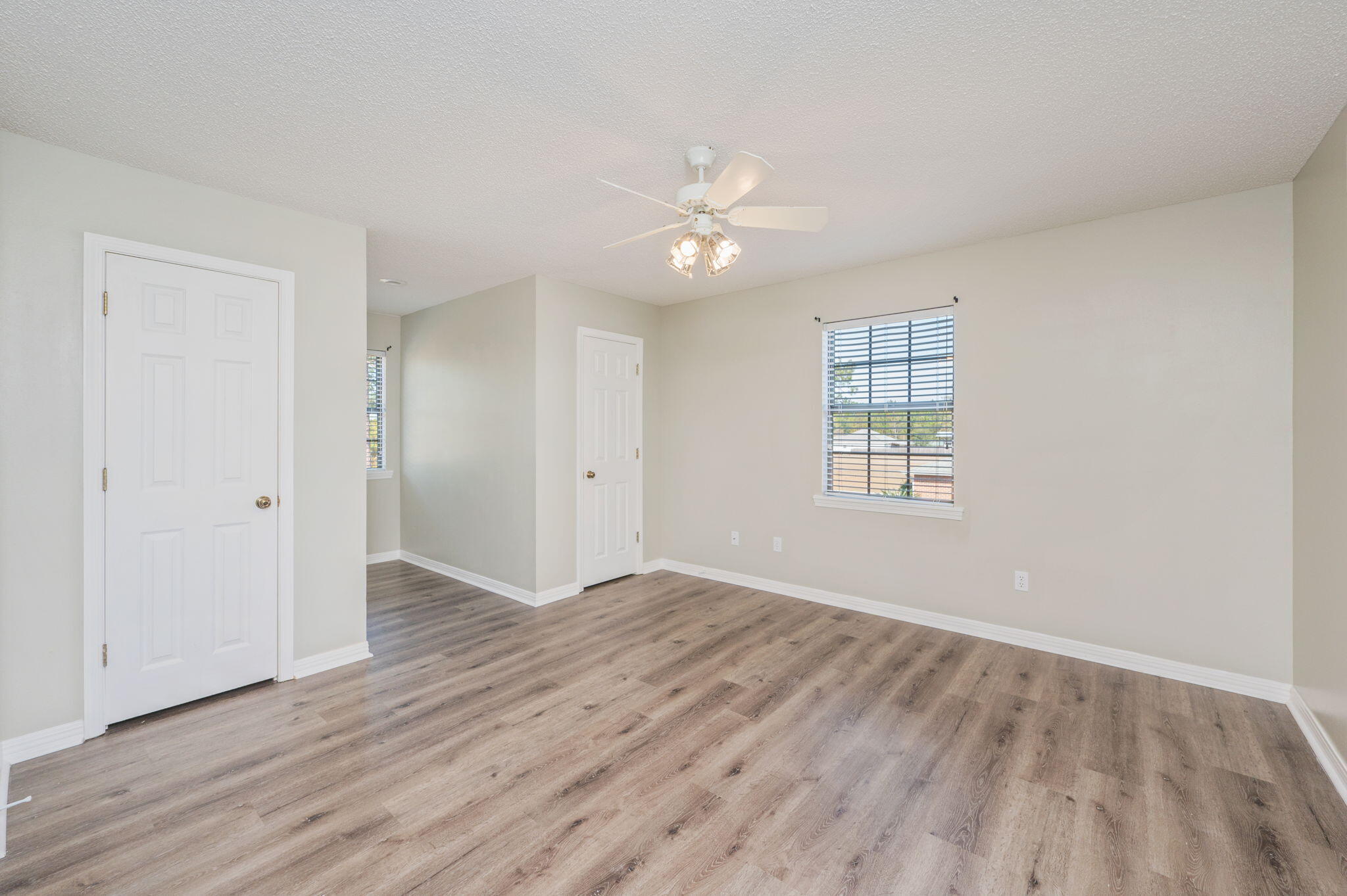 1136 10 Lake Drive DeFuniak Springs, FL 32433 - Photo 32 of 53 an empty room with wooden floor ceiling fan and windows