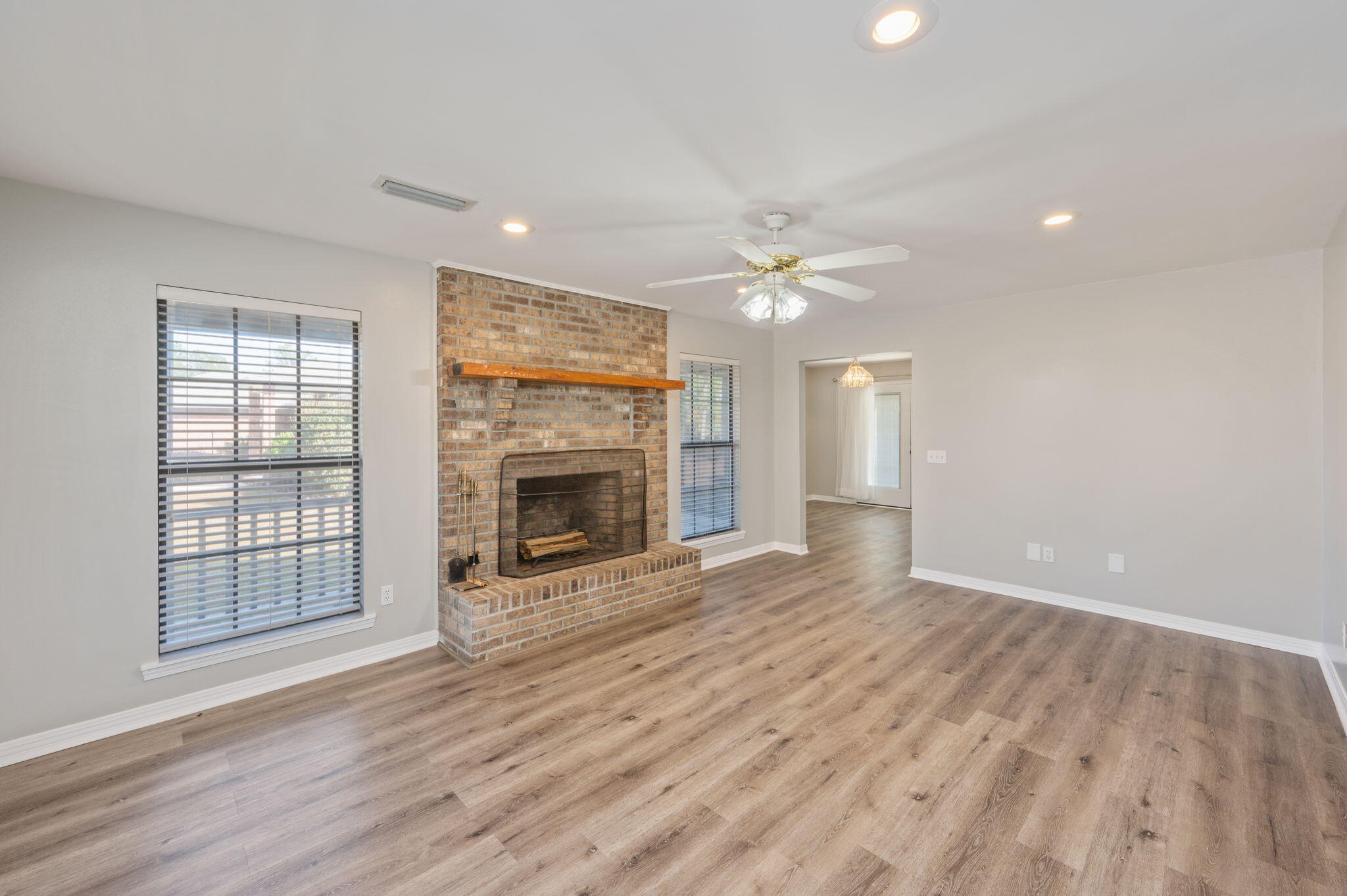 1136 10 Lake Drive DeFuniak Springs, FL 32433 - Photo 10 of 53 an empty room with wooden floor fireplace and windows