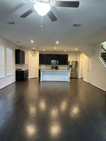 a view of kitchen with microwave a stove and wooden floor