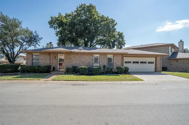 a front view of a house with a yard and trees