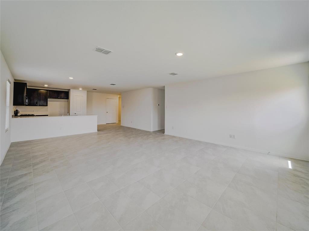357 Sun Bluff Road Fort Worth, TX 76052 - Photo 34 of 35 Open-concept interior featuring large format tile flooring, recessed lighting, a kitchen with dark cabinetry, and a white countertop with an integrated sink