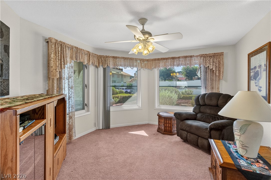 2055 Cholla Way Laughlin, NV 89029 - Photo 10 of 87 A naturally illuminated living room features a broad bay window overlooking the neighborhood and a central ceiling fan for comfort.