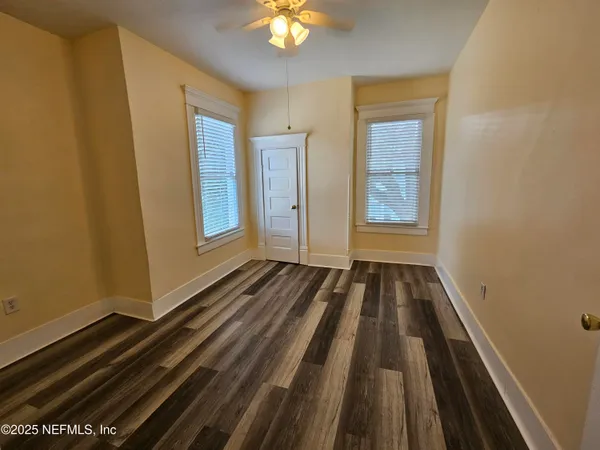 a view of a room with wooden floor and windows