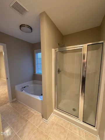 an empty room with a chandelier fan and windows