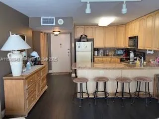 a kitchen with refrigerator and chairs