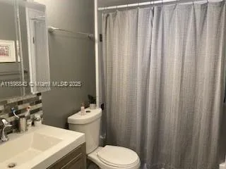 a bathroom with a sink a toilet and shower curtain