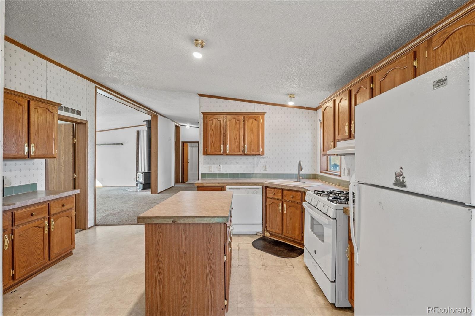 1711 Witcher Mtn. Road Guffey, CO 80820 - Photo 12 of 41 a kitchen with granite countertop a sink stove and refrigerator