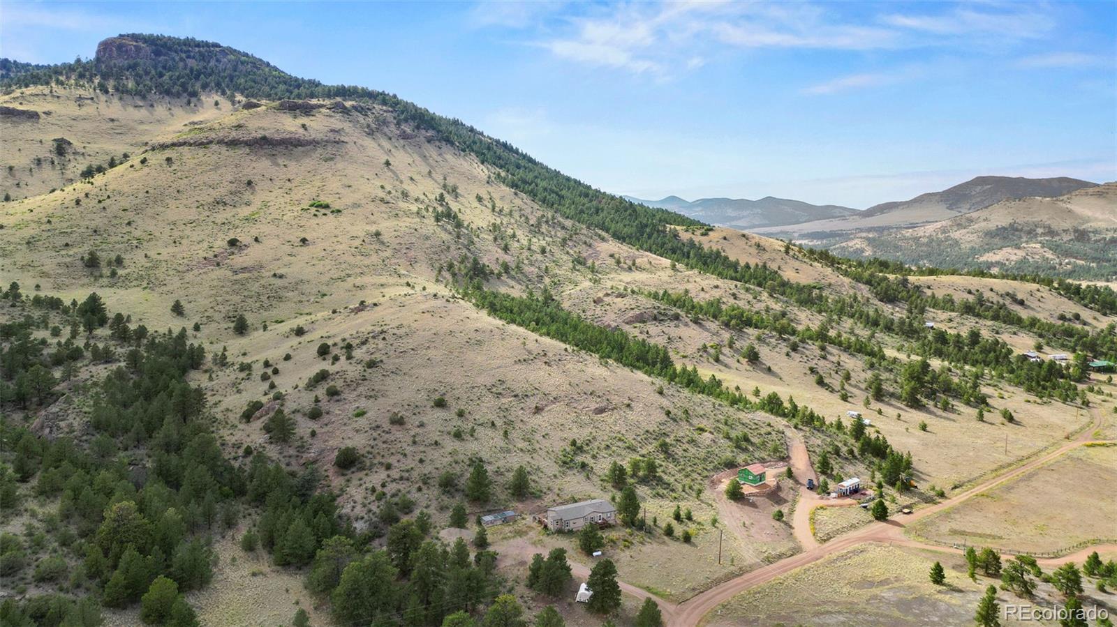 1711 Witcher Mtn. Road Guffey, CO 80820 - Photo 40 of 41 a view of a dry yard with mountains in the background