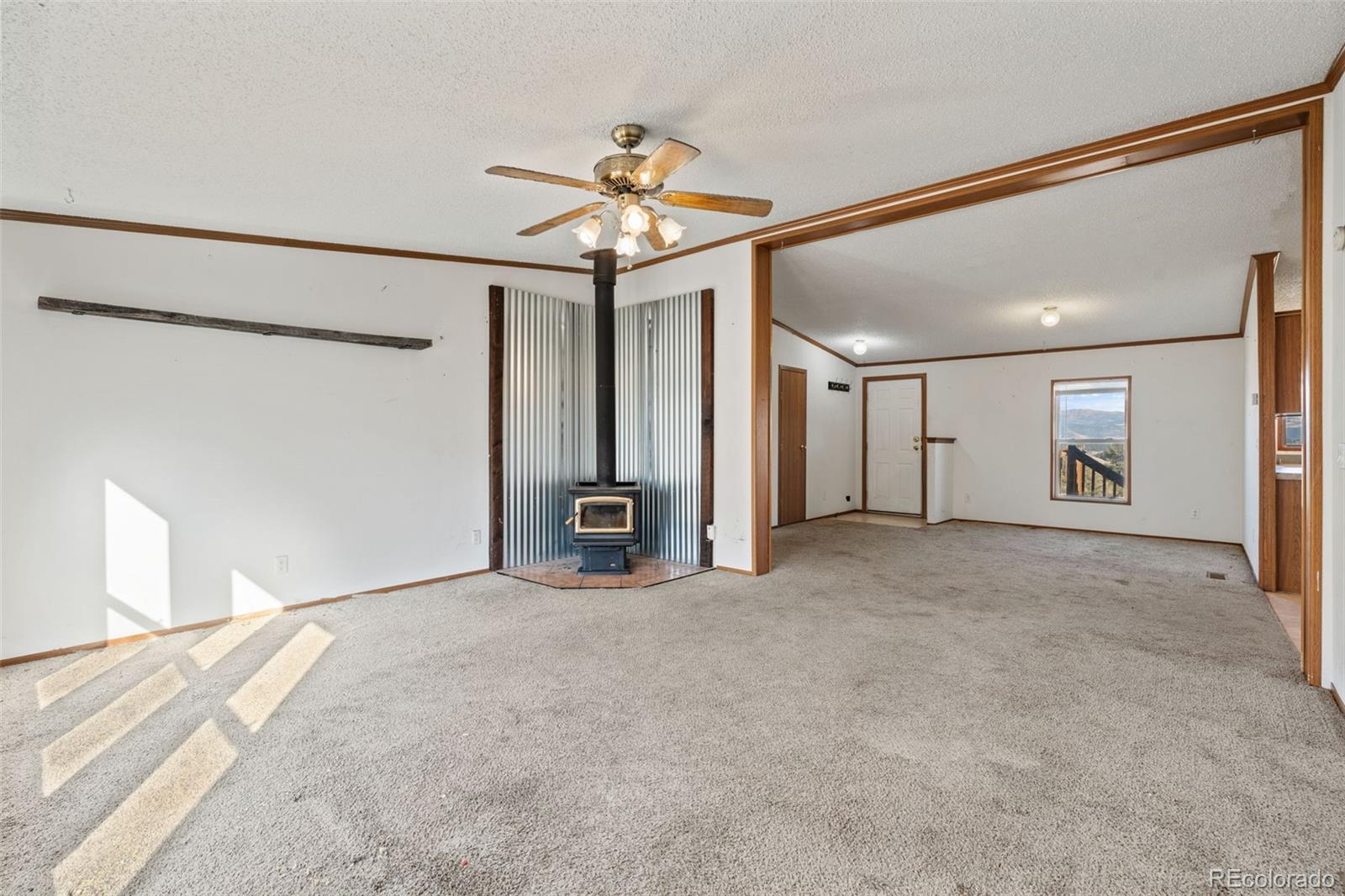 1711 Witcher Mtn. Road Guffey, CO 80820 - Photo 8 of 41 a view of a livingroom with a ceiling fan and refrigerator