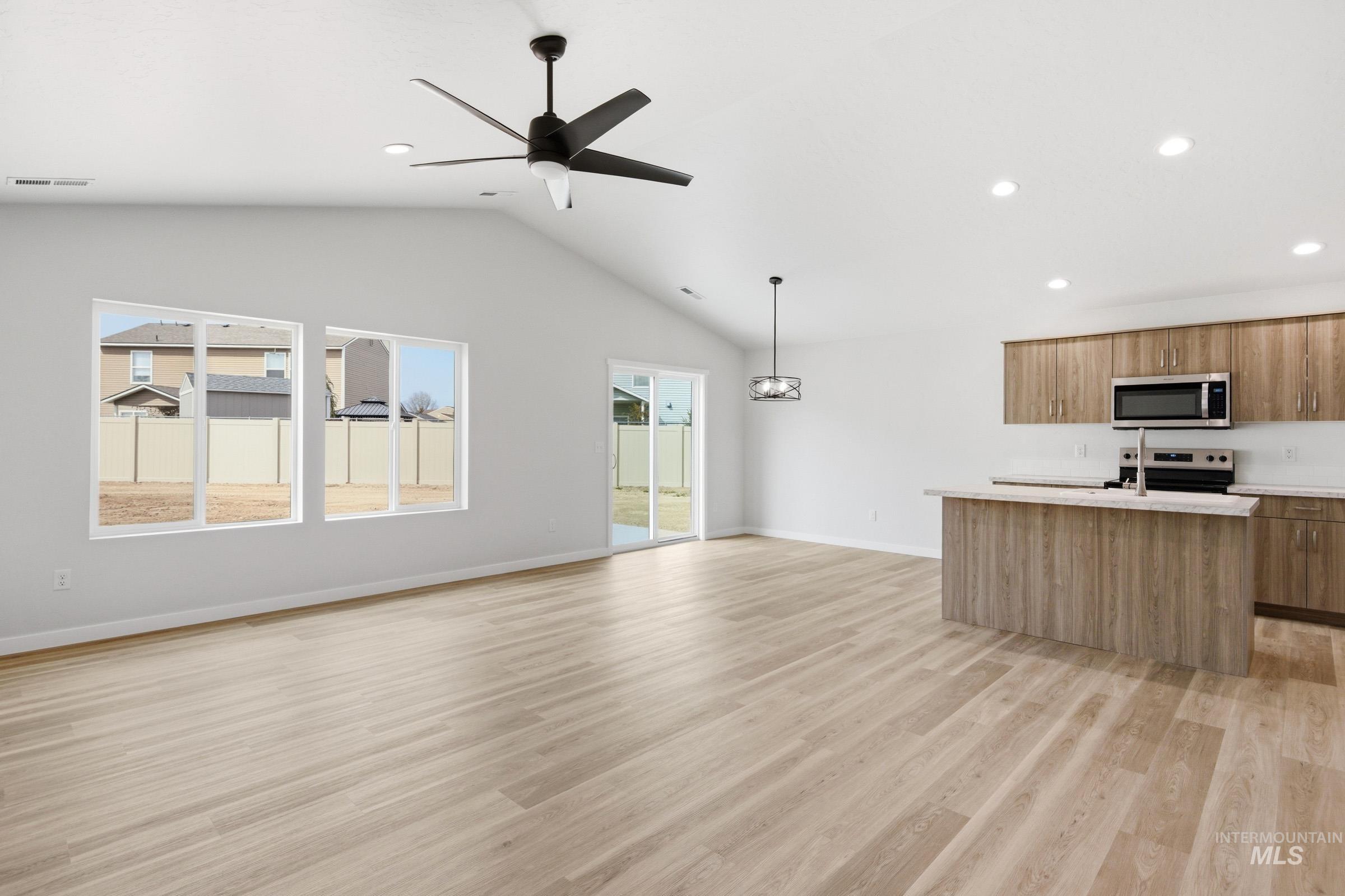 13735 Inman Court Caldwell, ID 83607 - Photo 20 of 20 Kitchen featuring open floor plan, a kitchen island with sink, modern cabinets, ceiling fan, and stainless steel appliances