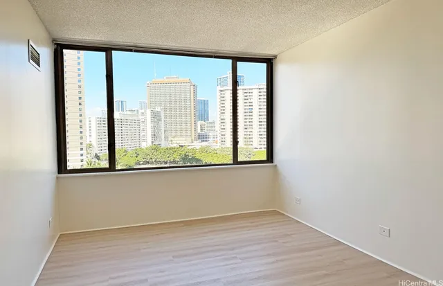 an empty room with wooden floor and a window