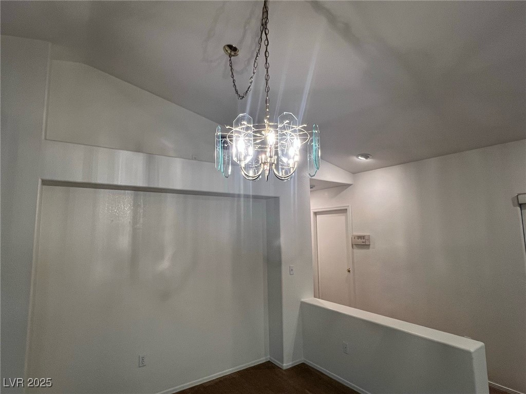 2306 Spring Water Drive Las Vegas, NV 89134 - Photo 11 of 24 Empty room featuring lofted ceiling, a chandelier, and dark wood finished floors