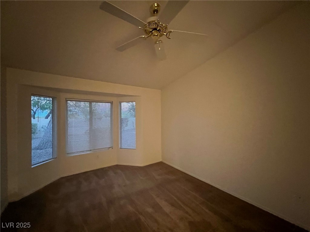 2306 Spring Water Drive Las Vegas, NV 89134 - Photo 14 of 24 Unfurnished room featuring vaulted ceiling, dark carpet, and healthy amount of natural light