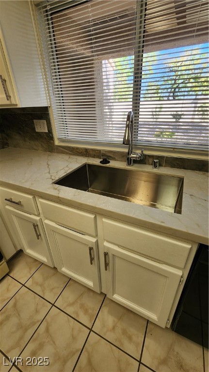 2306 Spring Water Drive Las Vegas, NV 89134 - Photo 6 of 24 Kitchen with white cabinets, light stone countertops, light tile patterned floors, and dishwashing machine