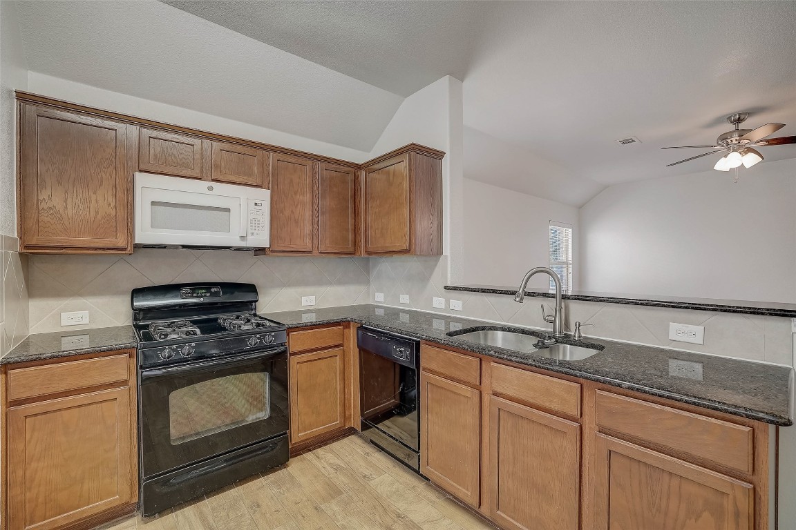 5800 Silver Screen Drive Austin, TX 78747 - Photo 11 of 31 a kitchen with granite countertop a sink cabinets and stainless steel appliances