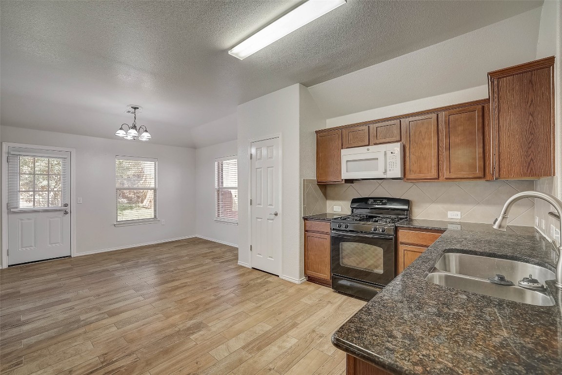 5800 Silver Screen Drive Austin, TX 78747 - Photo 12 of 31 a kitchen with granite countertop a stove sink and cabinets