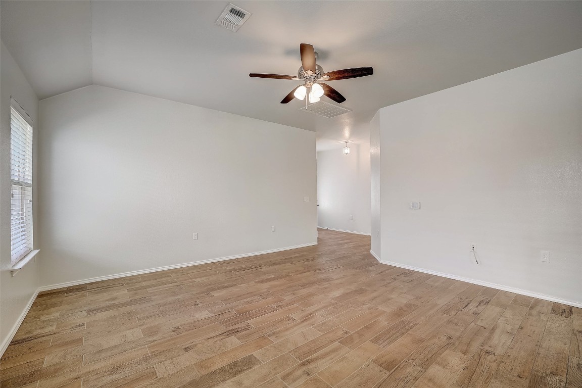 5800 Silver Screen Drive Austin, TX 78747 - Photo 8 of 31 an empty room with wooden floor fan and windows