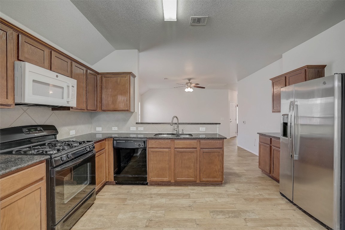 5800 Silver Screen Drive Austin, TX 78747 - Photo 10 of 31 a kitchen with stainless steel appliances granite countertop a stove a sink dishwasher and a refrigerator